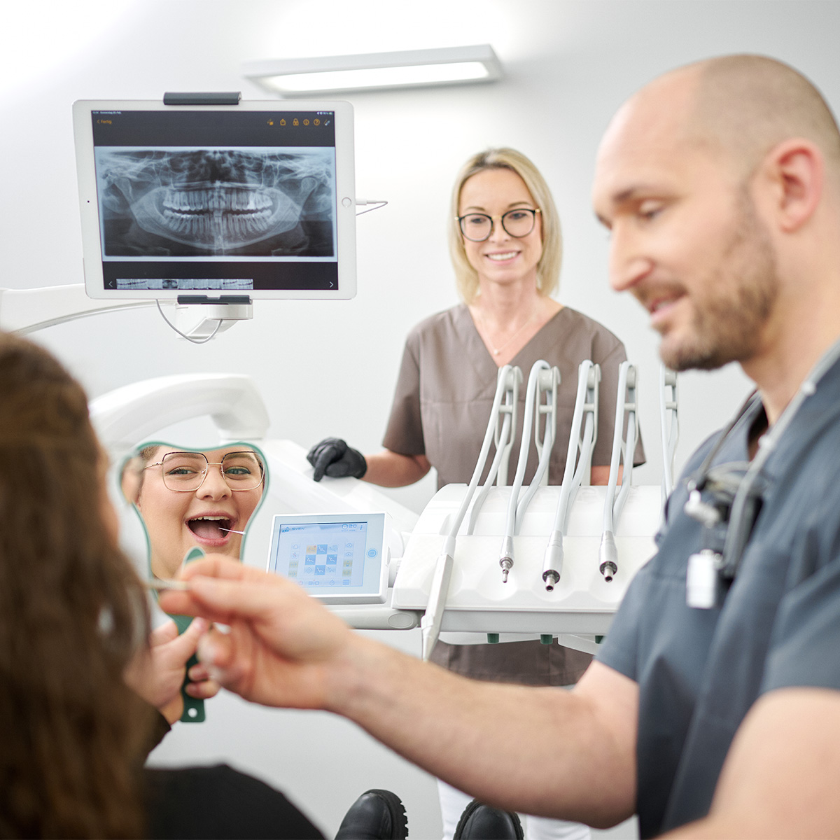 Zahnarzt Dentafamily Wiesentheid untersucht eine Patientin mit digitaler Röntgentechnik für eine präzise Zahnbehandlung.