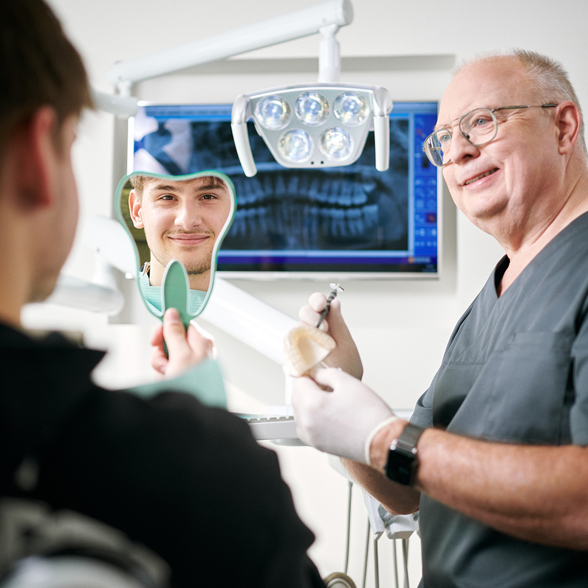 Zahnarzt Wiesentheid erklärt dem Patienten den Behandlungsplan mit Zahnersatz in der Zahnarztpraxis Dentafamily.